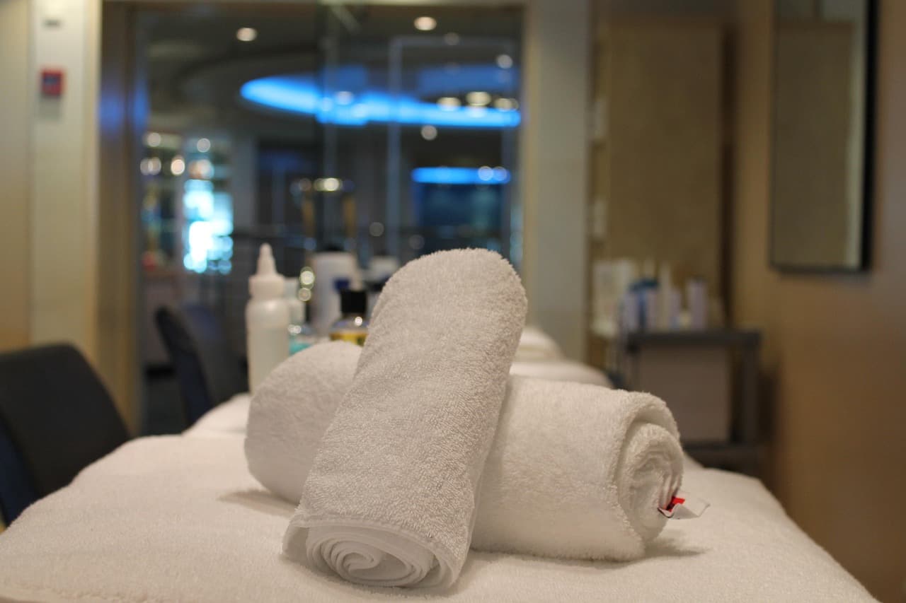 Rolled white towels laid out on a treatment bed