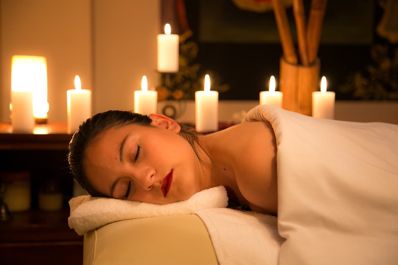 A client resting on a warm towel by candlelight